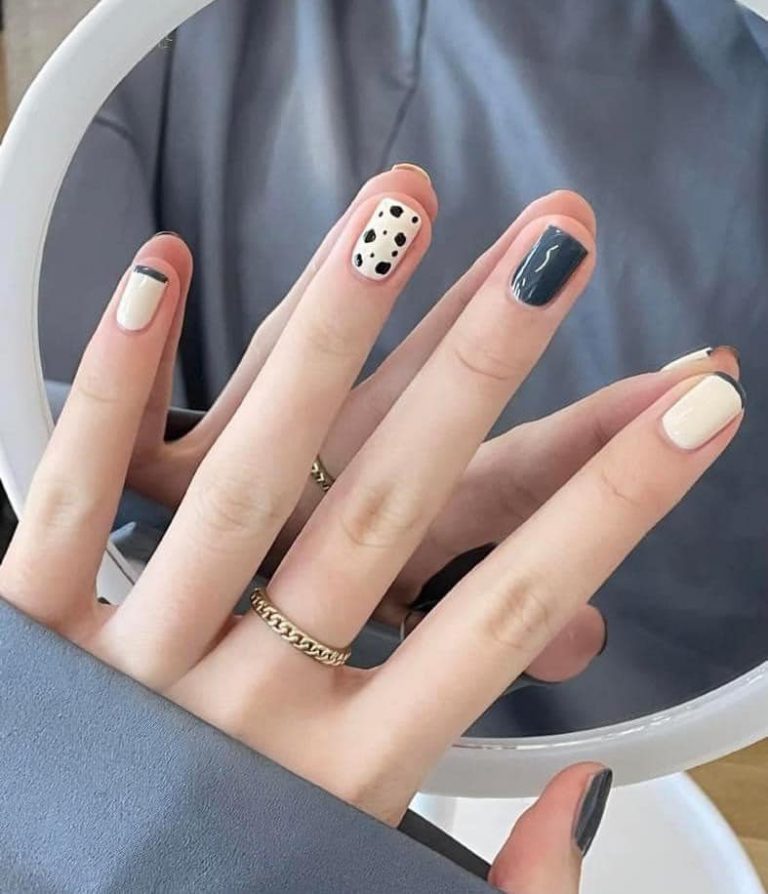 Black and cream nail design with a polka-dot accent nail