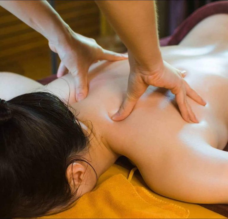 Close-up of hands massaging the shoulders and upper back