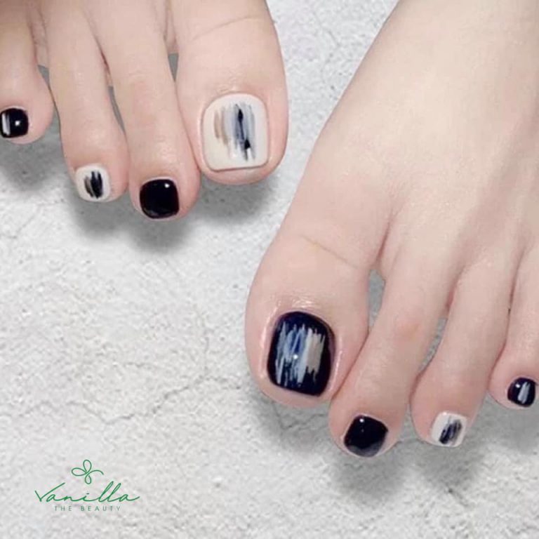 Black and white toenail design with brushstroke accents