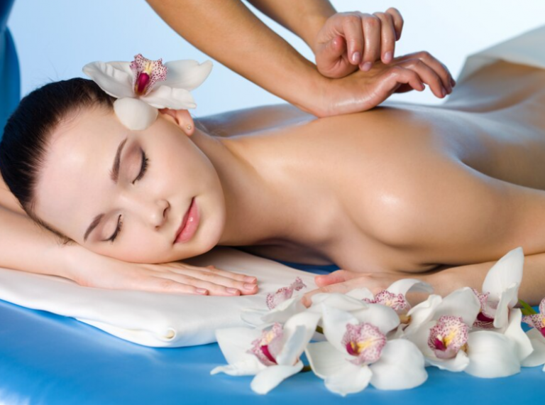 Massage therapist applying forearm pressure to the upper back