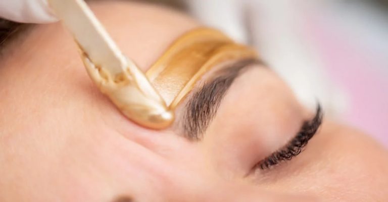Eyebrow waxing with a wooden applicator